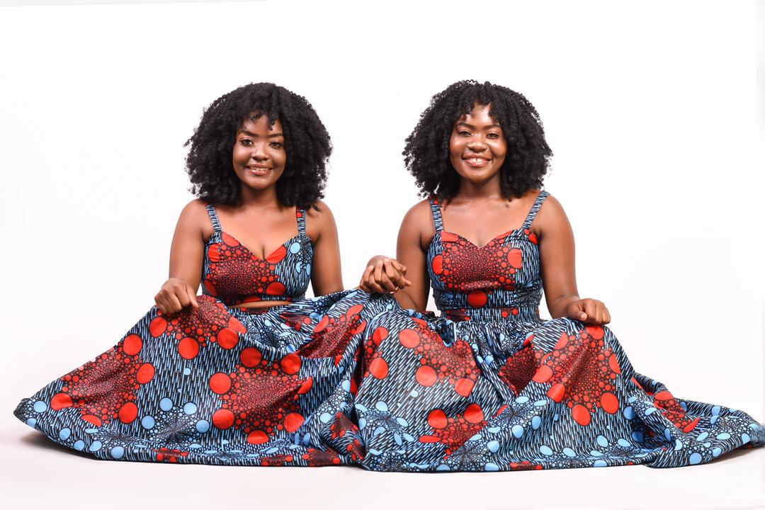 Seated together in patterned dresses