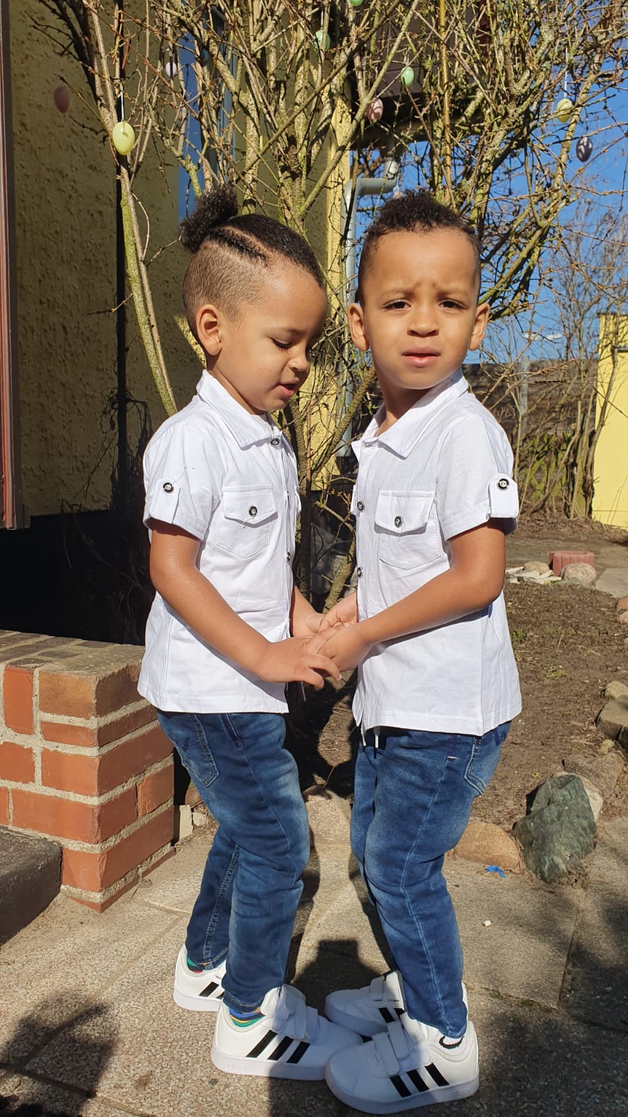 Two children in matching shirts and jeans
